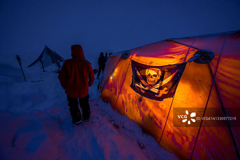 年轻男子在下雪的加拿大落基山脉中走向营地图片素材