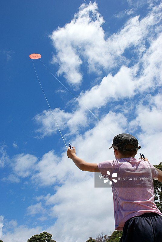 夏天，男孩在海滩上放特技风筝图片素材