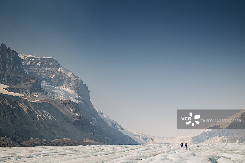 两名登山者走过壮观的阿萨巴斯卡冰川图片素材