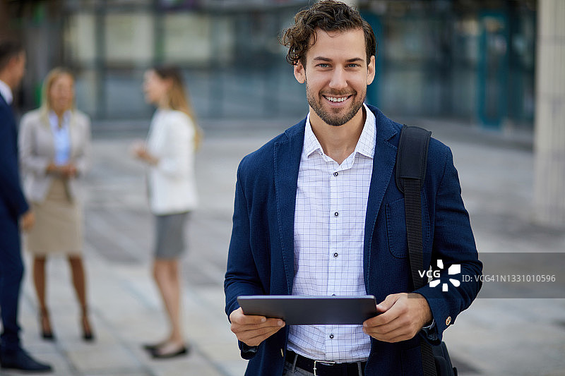 在户外使用平板电脑的年轻商人图片素材
