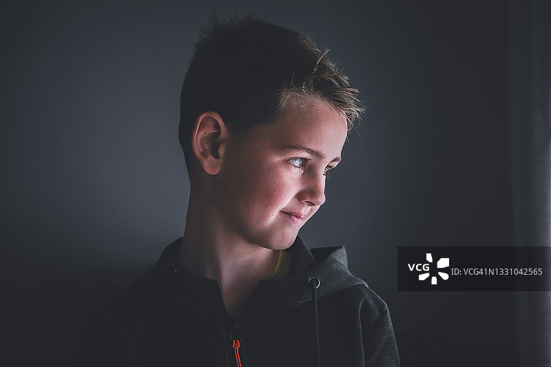 英俊的男孩回头向外看图片素材