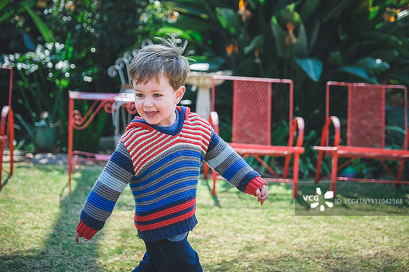 可爱的男孩面带灿烂的笑容跑离他的父亲图片素材