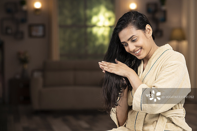 年轻女子在家穿浴袍做头部按摩的照片图片素材