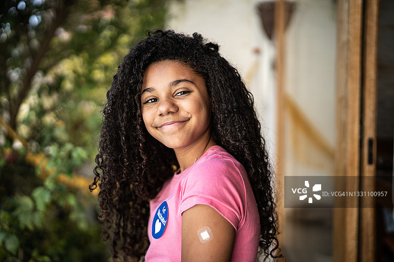 接种疫苗后展示手臂的女孩肖像图片素材