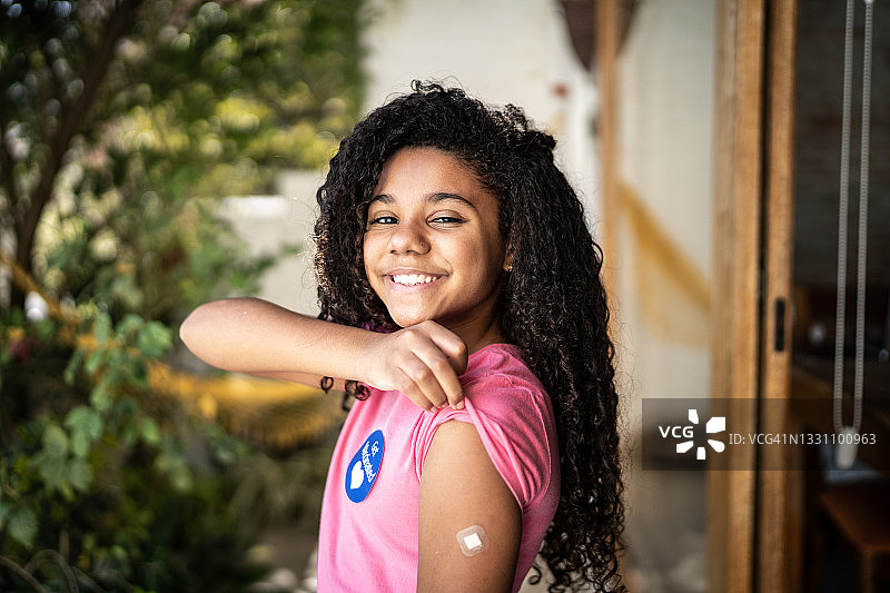 接种疫苗后展示手臂的女孩肖像图片素材