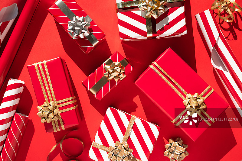 红色桌子上的红白礼品盒、丝带和包装纸图片素材
