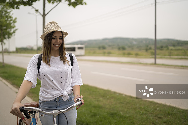 骑自行车的迷人年轻女人在微笑图片素材