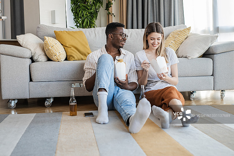 情侣在家中放松，享用饮品和外卖食物图片素材