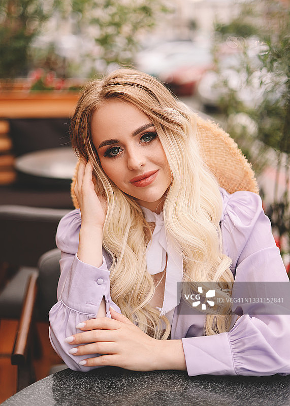 在咖啡馆阳台上等待约会的时尚女孩图片素材