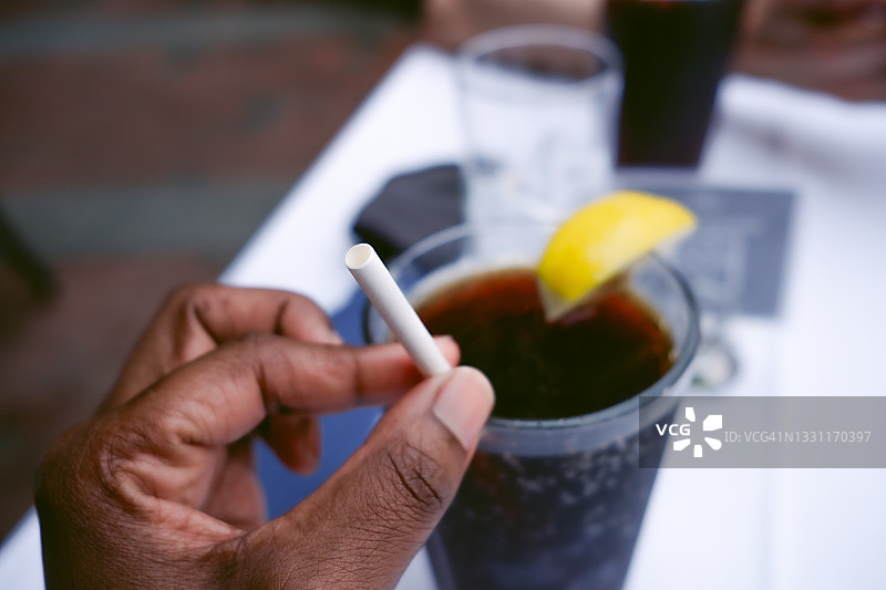 女人用环保纸吸管喝饮料图片素材