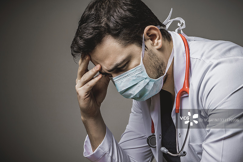 严肃的，工作过度，非常悲伤，沉思的男性医护人员和医生图片素材