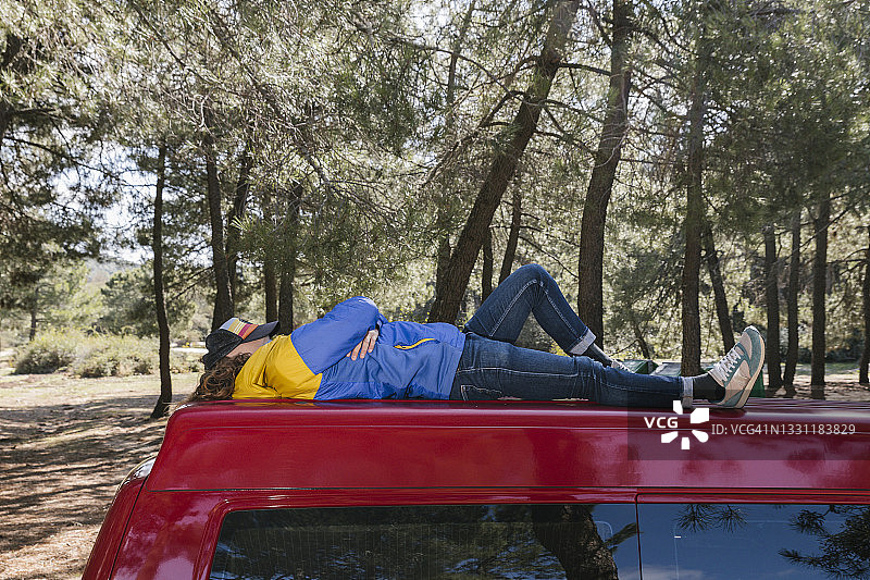 旅行的男人躺在货车车顶上放松休息图片素材
