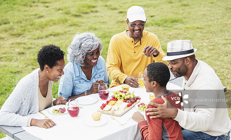 多代非裔美国家庭在野餐桌旁图片素材