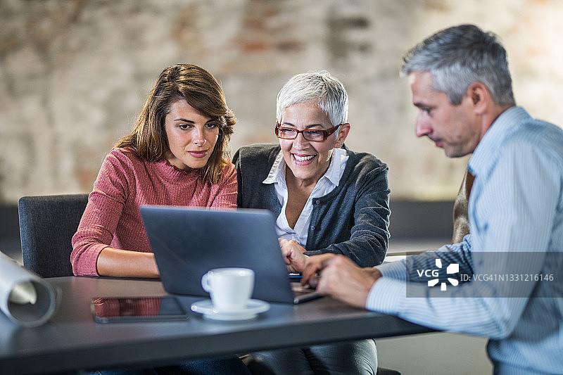 快乐母女与房产经纪人使用笔记本电脑图片素材
