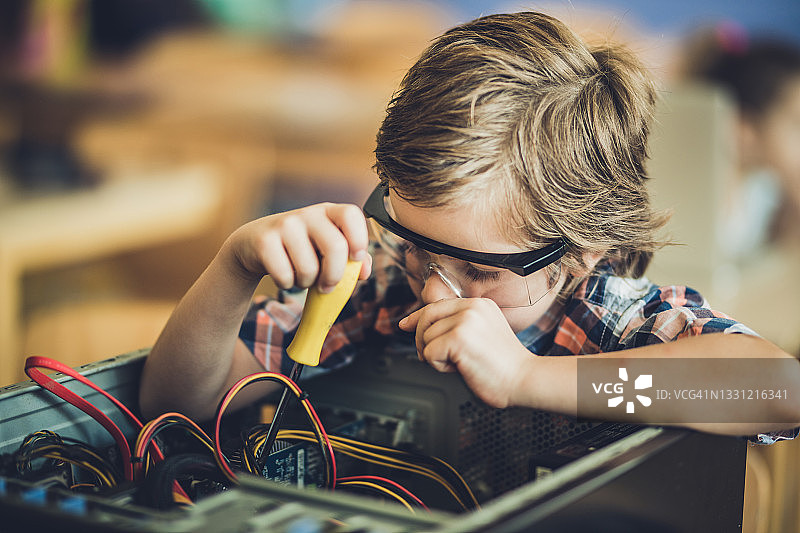 学生在教室里修理电脑零件图片素材
