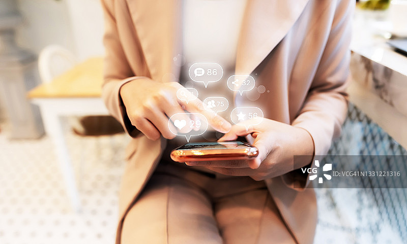 女人使用手机智能手机，带有社交媒体和社交网络图标。在线营销概念图片素材