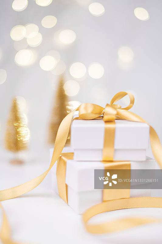 散景背景上的金色丝带白色礼品盒堆图片素材