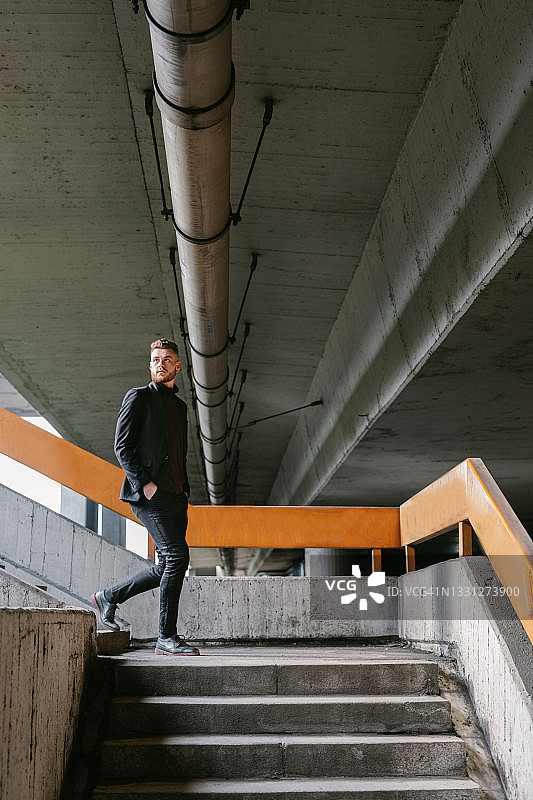 穿着考究的年轻商人走下桥上的楼梯图片素材