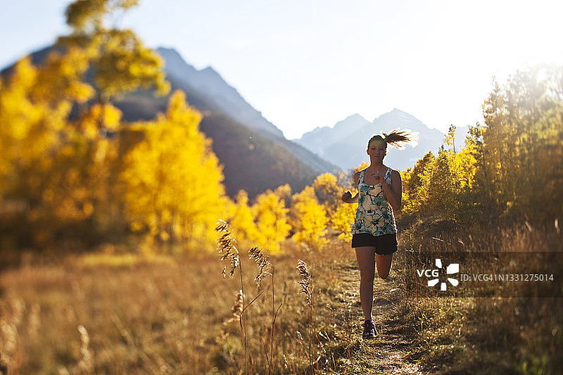年轻女人在秋色中越野跑图片素材