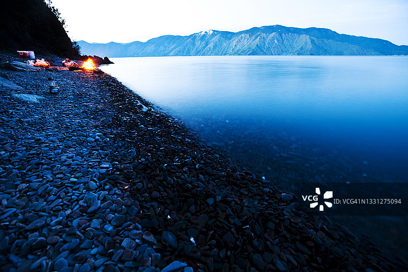 爱达荷州，日落时分营地边缘的篝火和美丽的湖泊图片素材