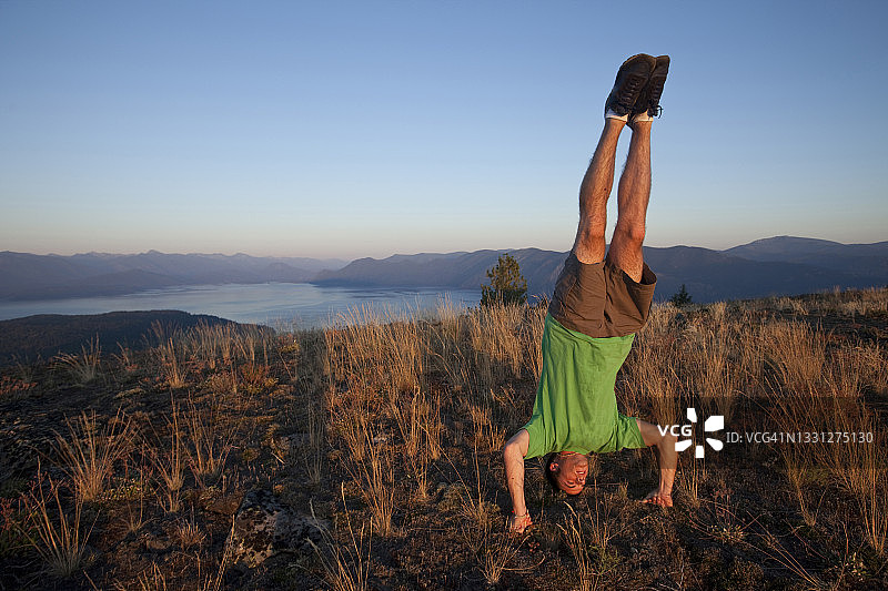 年轻男人在爱达荷州日落时倒立图片素材