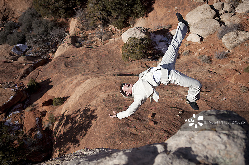 身穿条纹西装的男人从悬崖上摔下来图片素材