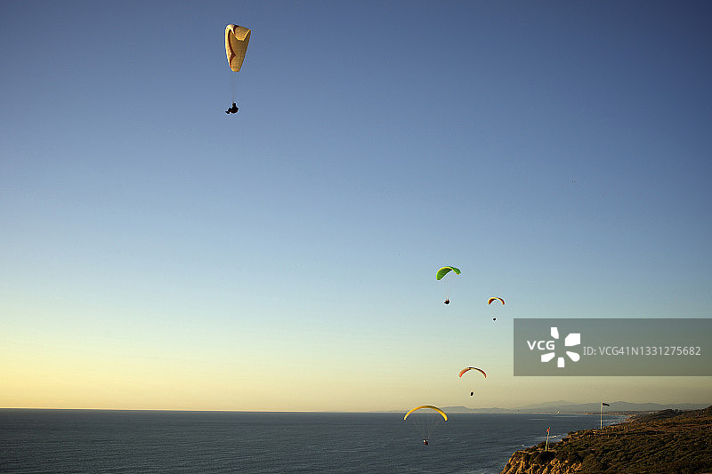 五名滑翔伞运动员在加利福尼亚州日落时分乘风飞翔图片素材