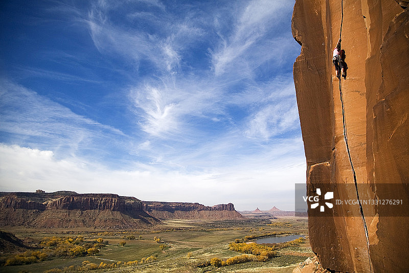 一位女攀岩者在犹他州印第安克里克攀登一条名为“疤面”的经典路线，评级为5.11a。图片素材