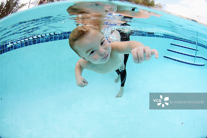 小男孩在上婴儿游泳课时在水下游泳图片素材