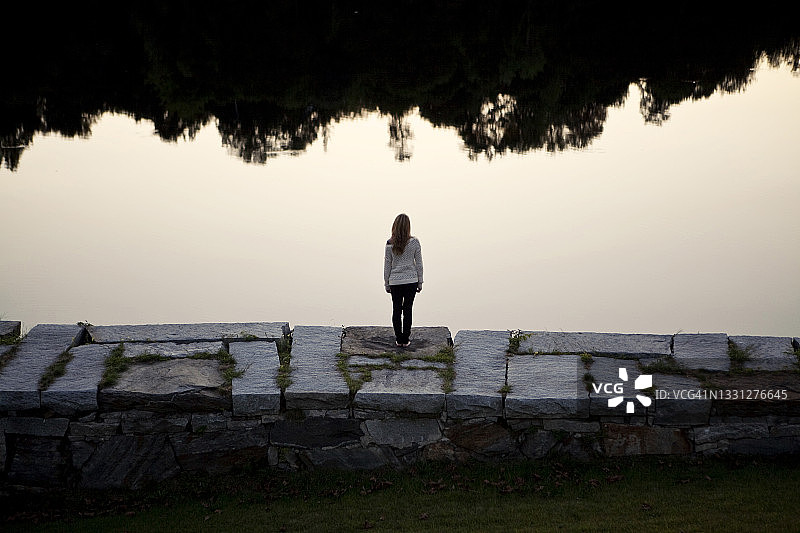 站在石墙上俯瞰河流的女子图片素材