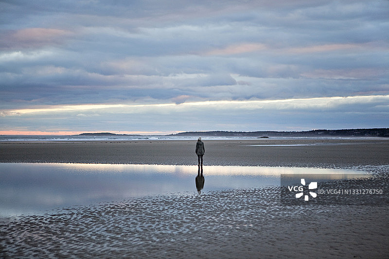 女子倒影在缅因州海滩的潮汐池中图片素材