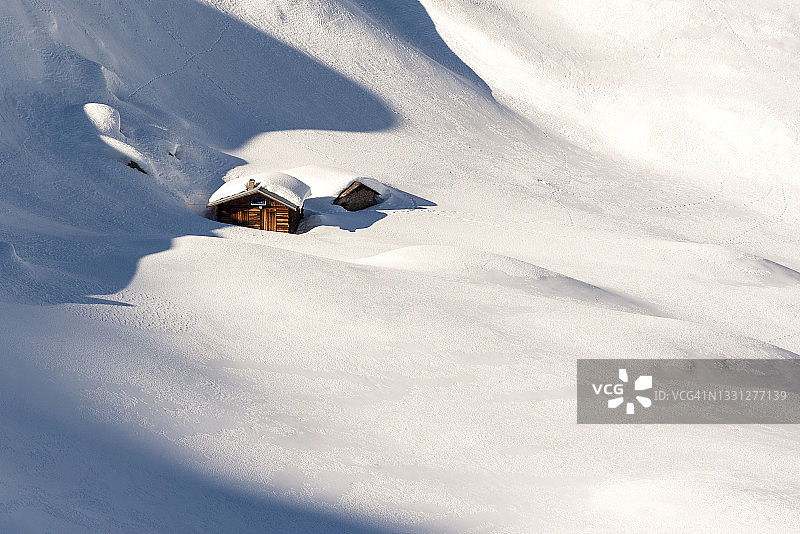 被白雪覆盖的小山间小屋图片素材