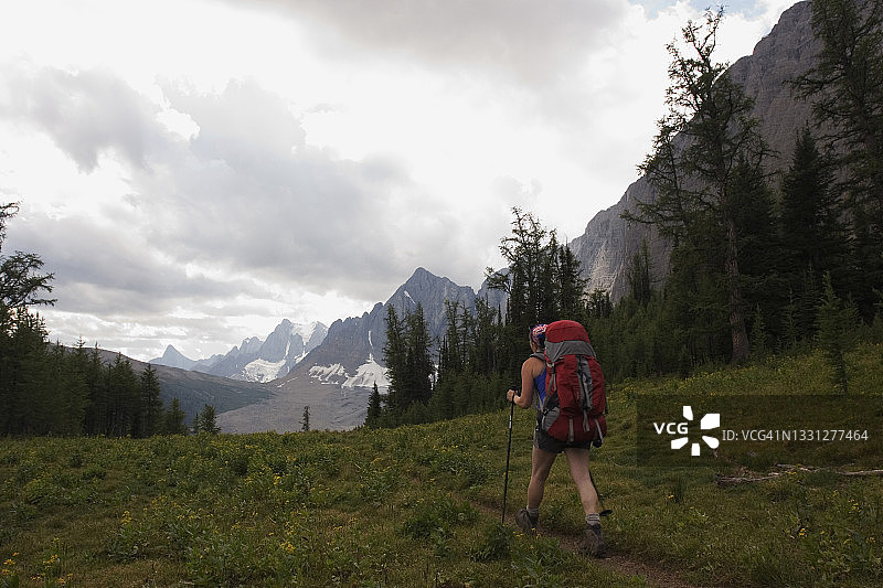 三十出头的女性背包客在库特尼国家公园的石墙小径上徒步旅行图片素材
