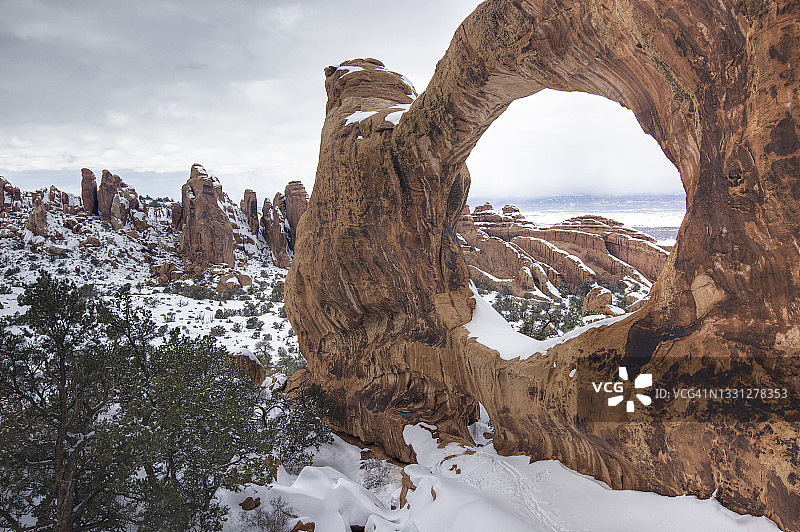 冬季雪景中的天然岩石拱门图片素材
