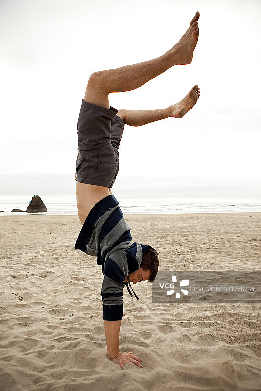 男人在海滩上做手倒立图片素材