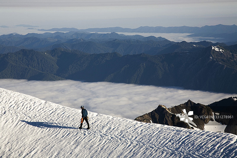 登山者走向华盛顿州奥林匹克国家公园的白雪皑皑的山顶图片素材