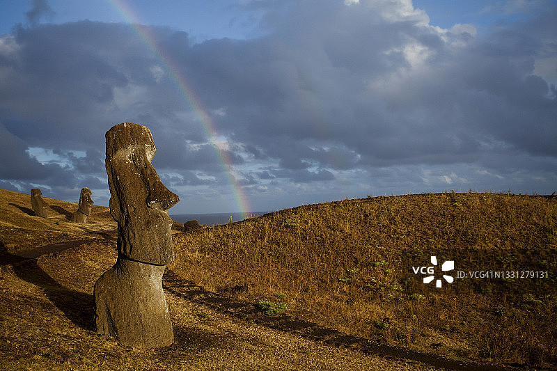 世界最偏远岛屿上，黄昏时分的彩虹与摩艾石像图片素材