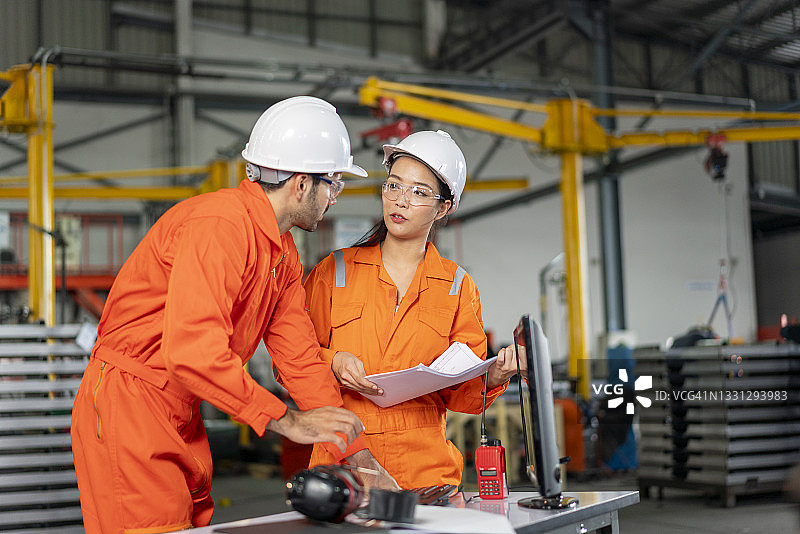 一位成熟的工业男女工程师在工厂里用笔记本电脑工作图片素材