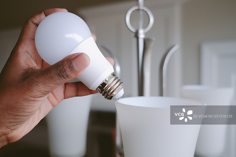 女人更换LED灯泡图片素材