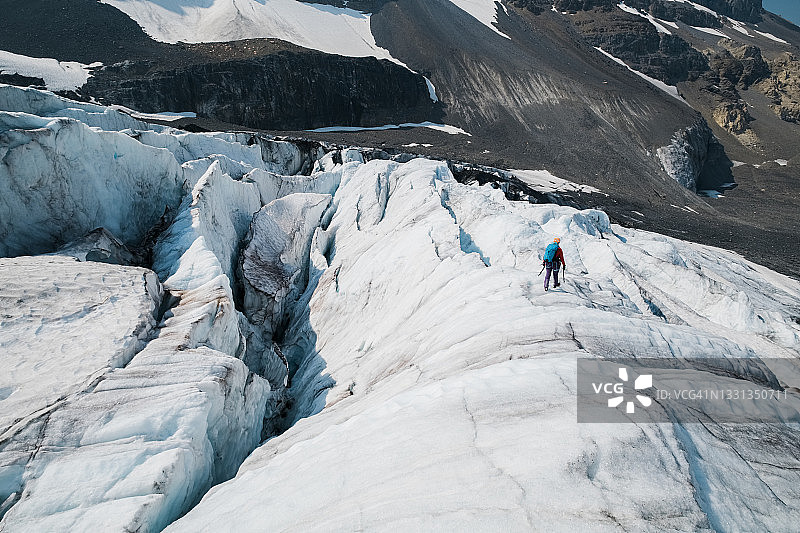 登山者在阿塔巴斯卡冰川的大冰缝间徒步图片素材