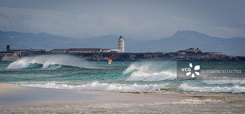 在西班牙安达卢西亚加的斯塔里法灯塔前玩风筝冲浪的人图片素材