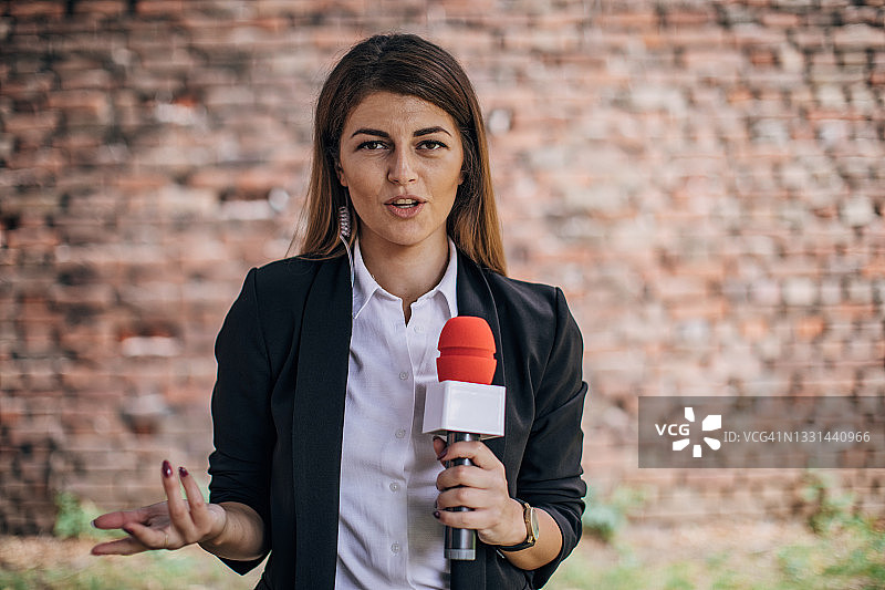 女记者新闻直播对着镜头讲话图片素材