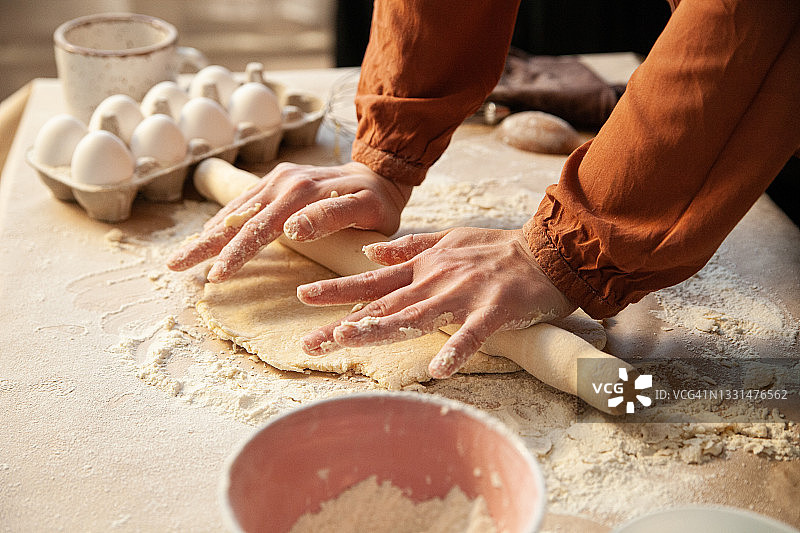 裁剪的家庭主妇在桌子上擀面图片素材