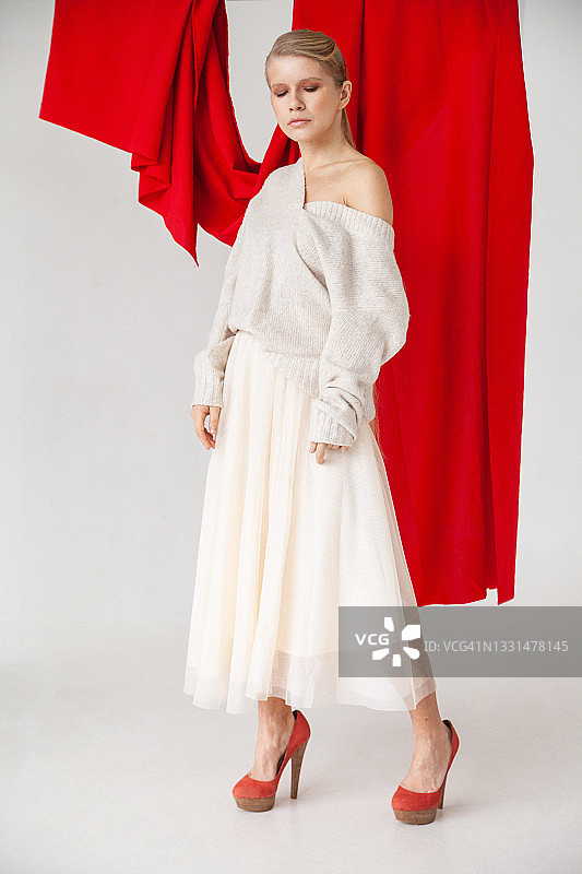 身穿时尚服装的女人，背景是红色面料图片素材