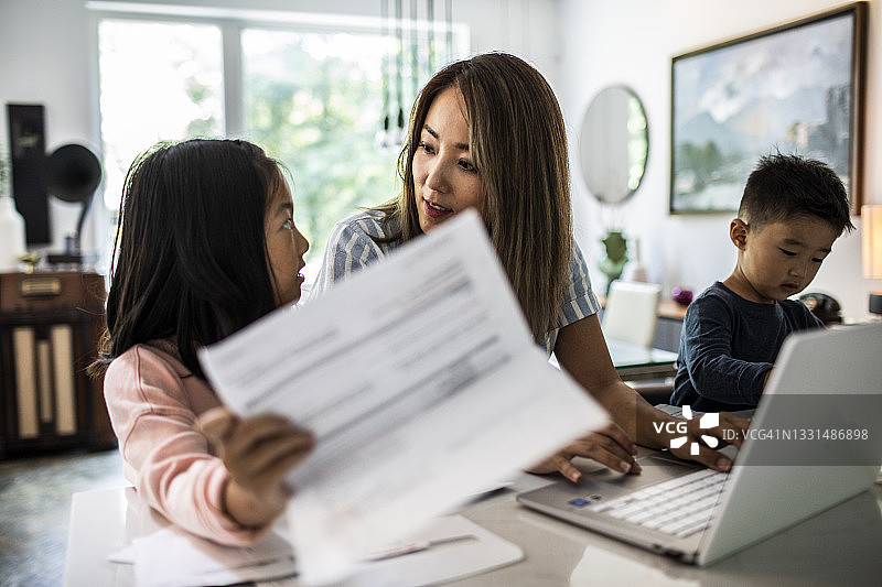 母亲在家工作，孩子们在身边图片素材