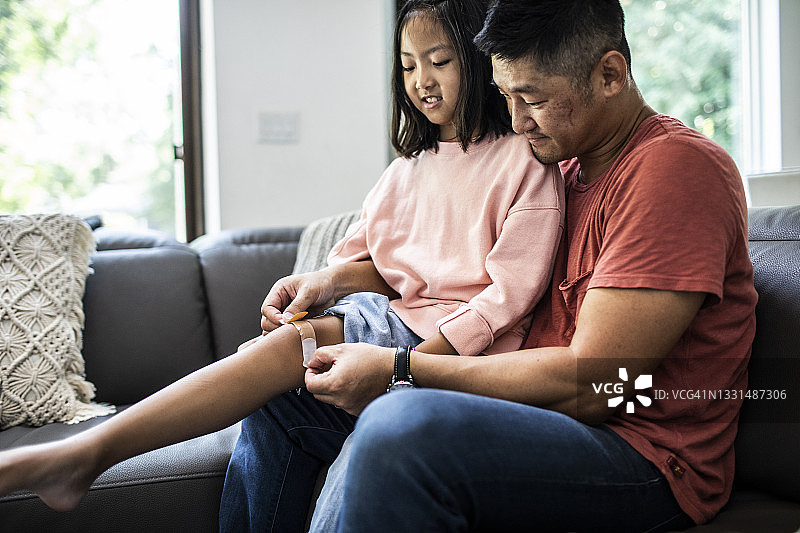 父亲给女儿贴创可贴图片素材