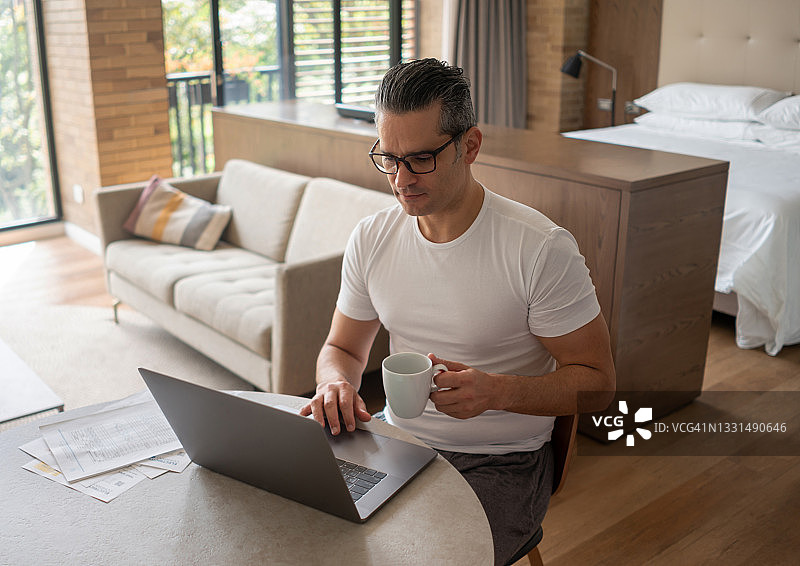 在家用笔记本电脑喝咖啡的男人图片素材