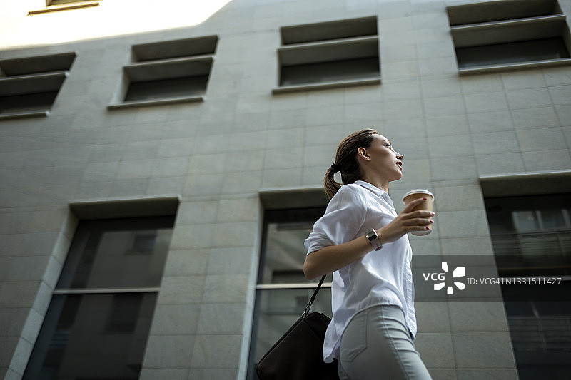 喝咖啡准备工作的时尚年轻商务女性图片素材