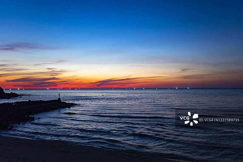 夜晚逼近的海面与渔火图片素材