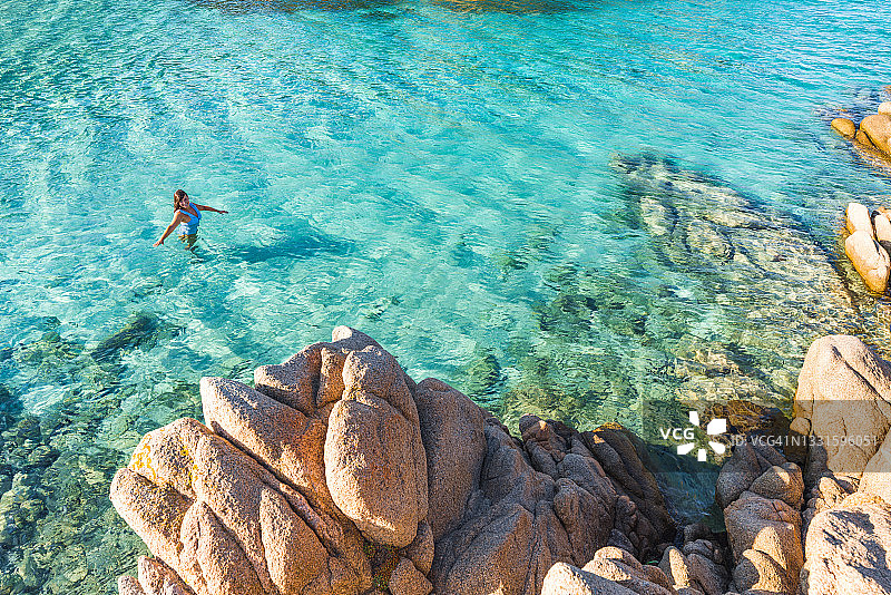 女人在意大利撒丁岛卡普雷拉岛的卡拉那波勒塔纳海湾沐浴图片素材